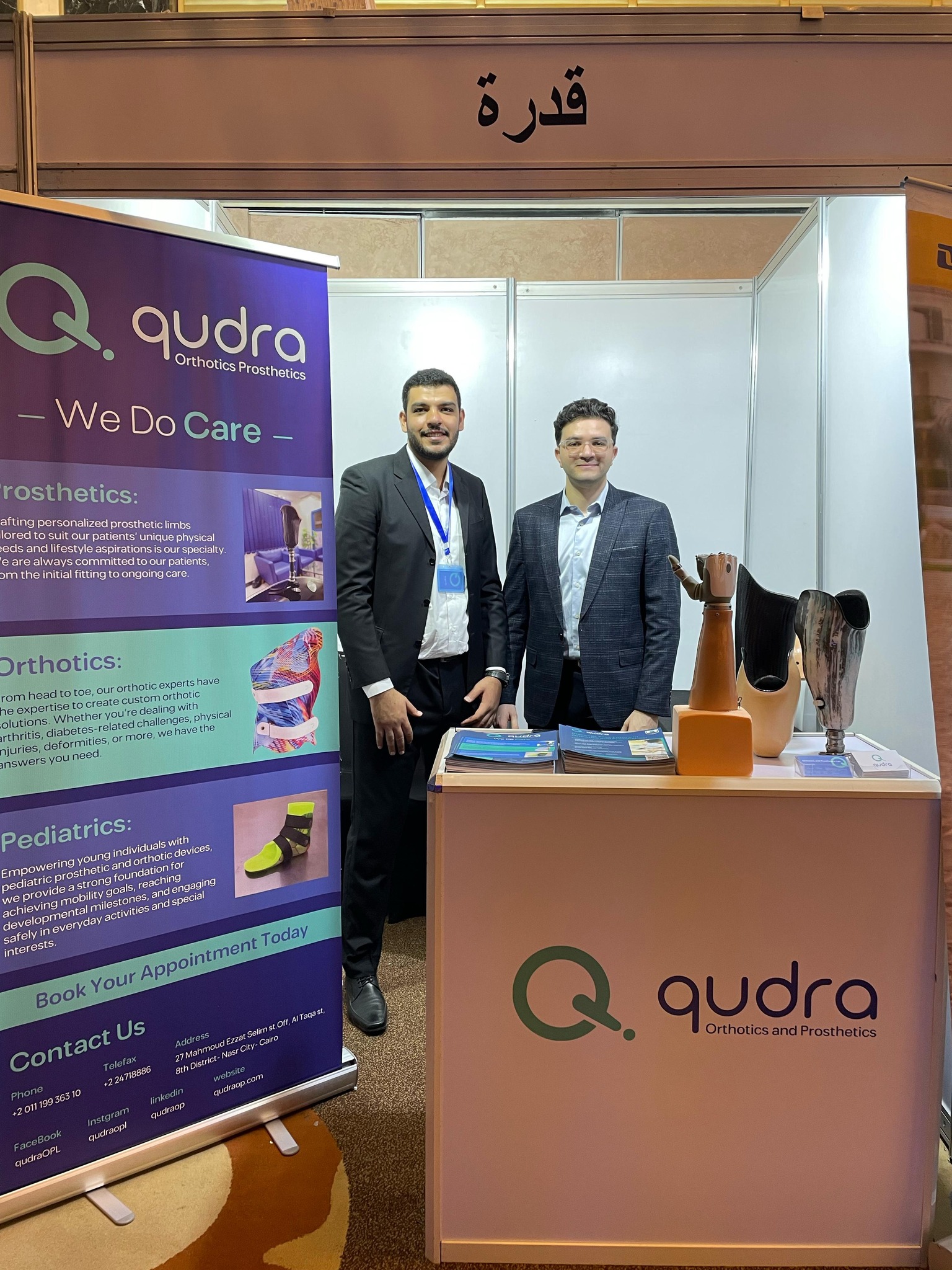 Qudra prosthetics team at a medical exhibition stand with prosthetic limbs on display